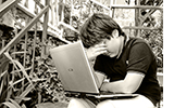 Children are faced with cyberbullying when hurtful information is posted online child with laptop wiping crying eyes